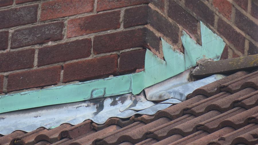 Close inspection of defective chimney flashing