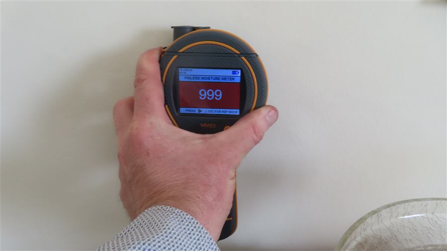 Moisture meter showing an elevated damp reading